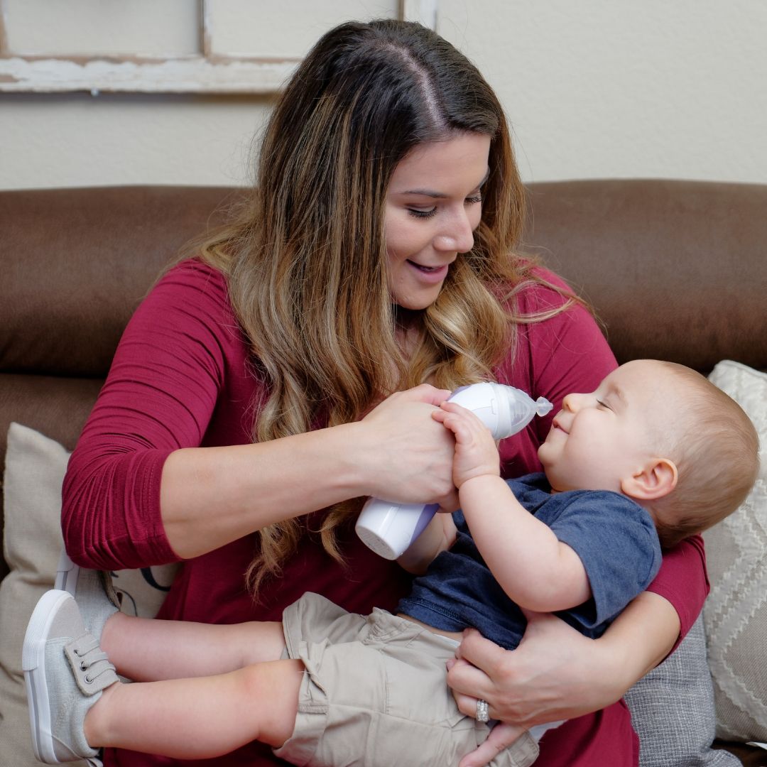 A mother using CLEARinse to safely and effectively clear her baby's nasal passages